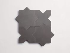 a square shaped tile with four intersecting pieces on it's side, all in grey