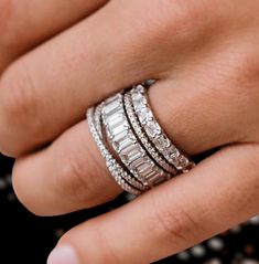 a woman's hand with three rings on her finger and one ring in the middle