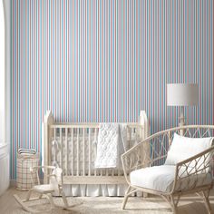 a baby's room with striped wallpaper and rocking chair in front of the crib