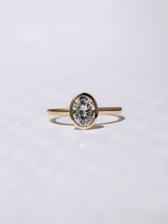 a gold ring with a white diamond in the center