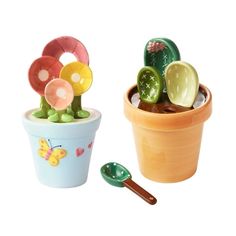 there are two pots with plants in them and one has a spoon on the side