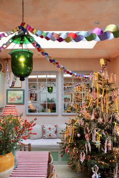 a decorated christmas tree sitting in the middle of a living room next to a window