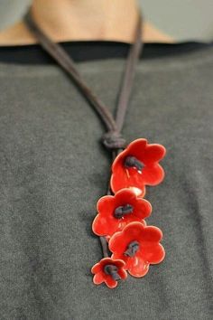 a necklace with three red flowers attached to it