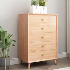 a wooden dresser next to a potted plant