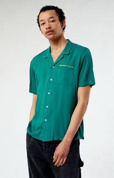 Elevate your style with the Beverly Hills Embroidered Camp Shirt from PacSun. This shirt features a collared neckline, short sleeves, button closures, and an embroidered design for a trendy and distinctive look. Whether you're hitting the streets or hanging out with friends, this camp shirt adds a touch of cool and casual sophistication to your wardrobe.


	Collared neckline
	Short sleeves
	Standard fit
	Button closures
	Left chest & back embroidery
	100% Rayon
	Machine washable
	Model is we Desert Shade, Pacsun Mens, Back Embroidery, Corporate Uniforms, Camp Shirt, Short Sleeve Button Up, Camping Shirt, Embroidered Design, Pacsun