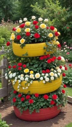 three yellow tires are stacked on top of each other with flowers growing out of them