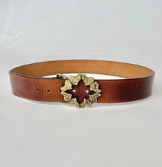 "A vintage belt circa 1970s made in thick and sturdy warm brown leather. Cute heavy weight brass buckle with brutalist style abstract hearts design. Bucked can be removed, band has a snap closure. Buckle loops though and attached with prong on adjustable holes. Perfect worn on the hip with jeans or at the waist. Marked: stamp on band is illegible, buckle reads slid brass but no signature Best fits size: Large  depending on how you wear it. Please see measurements to be sure! Can fit 36-39\" wais Vintage Distressed Brown Belt Buckles, Vintage Antique Buckle Belt In Distressed Brown, Vintage Distressed Brown Belt Buckle With Antique Detail, Vintage Distressed Brown Belt Buckles With Antique Buckle, Vintage Brown Belt Buckles With Matching Belt, Retro Brown Belt Buckle With Belt Included, Artisan Brown Belt With Antique Buckle, Brown Artisan Belt With Antique Buckle, Vintage Brown Belt Buckles With Brass Buckle