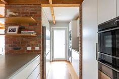 an open kitchen with brick walls and white cabinets