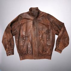 Introducing this unique 1980s vintage distressed leather Bomber Jacket in a rustic brown!  Perfect for those with a love for vintage fashion, this leather jacket exudes cool, retro vibes. The distressed look design adds a touch of edginess, while the brown leather gives it a classic look. Stand out from the crowd in this one-of-a-kind piece that combines style and nostalgia effortlessly. Add this statement jacket to your collection and rock a timeless look with a modern twist. DRY CLEANED since Vintage Brown Rugged Leather Jacket For Fall, Rugged Brown Leather Jacket, Vintage Distressed Outerwear For Fall, Vintage Brown Rugged Leather Jacket For Winter, Rugged Vintage Brown Leather Jacket For Winter, Distressed Brown Leather Jacket With Long Sleeves, Brown Distressed Leather Jacket With Long Sleeves, Vintage Distressed Leather Outerwear, Distressed Rugged Brown Outerwear