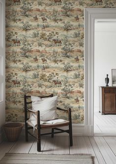 a chair sitting in front of a wallpaper with horses on it and a rug