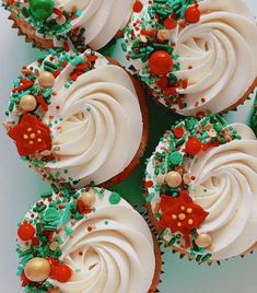 cupcakes with white frosting and green sprinkles are arranged on a plate