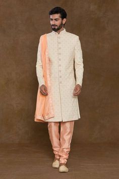 Off-white sherwani featuring thread, bead hand embroidery all over. Paired with a orange churidar and an embroidered hem dupatta. - Aza Fashions Orange Zari Work Sherwani For Wedding, Orange Sherwani With Zari Work For Wedding, Orange Wedding Sherwani With Zari Work, Wedding Orange Sherwani With Zari Work, Orange Sherwani For Wedding Eid Festival, Orange Sherwani For Wedding And Eid, Orange Sherwani For Wedding At Eid, Orange Kurta With Intricate Embroidery For Wedding, Orange Embroidered Kurta For Wedding