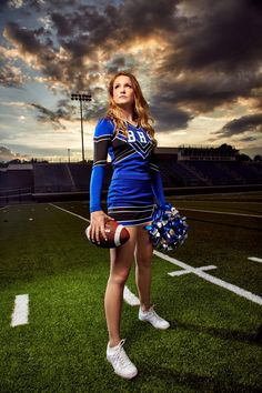 a cheerleader is posing for a photo on the football field with her hand in her pocket