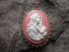 "Wonderful look for Easter and Christmas!! Beautiful Virgin Mary cradling baby Jesus cameo necklaces, choose purple, pink, blue or gray background. The cameos are gorgeous. I do have many other colors, finishes and styles, so please do browse, I can make any larger cameo in my shop into this pretty necklace, so browse and message me with a custom order The pretty setting is classically beautiful rose gold tone, which measures about 2 1/4\" long. The chain is a matching 24\" rose gold link chain Personalized Pink Jewelry For Christmas, Handmade Pink Jewelry For Holiday, Vintage Pink Necklace For Mother's Day, Handmade Pink Jewelry For Christmas, Handmade Pink Necklace For Mother's Day, Pink Cameo Necklace For Gifts, Pink Cameo Jewelry As A Gift, Cameo Pendant Necklace, Pretty Necklace