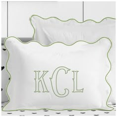 two pillows with the letters k c l and an embroidered monogrammed pillow case