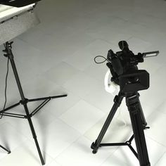 a camera and tripod on a white floor