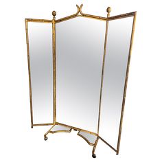 two mirrors sitting next to each other on top of a white flooring area with gold trimmings