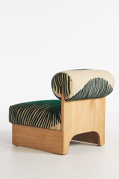 a zebra print chair sitting on top of a white floor next to a green cushion