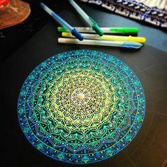 a table topped with lots of different colored pens and paper next to a drawing board