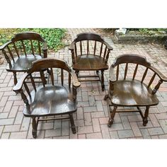 four wooden chairs sitting on top of a brick floor