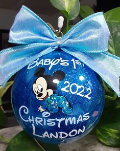 a blue ornament with a mickey mouse on it that says baby's first christmas