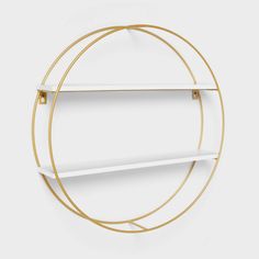 a white and gold circular shelf with two shelves on each side, in the shape of a circle