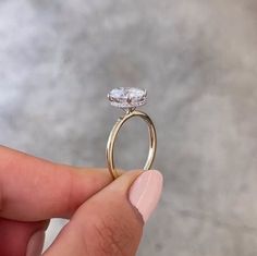 a person holding a diamond ring in their hand