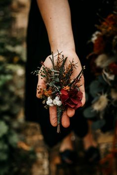 a person holding flowers in their hand