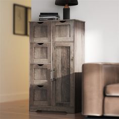 a large wooden cabinet sitting on top of a hard wood floor next to a chair