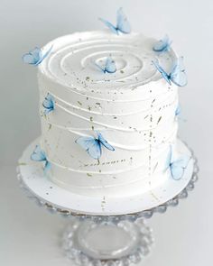 a white cake with blue butterflies on it