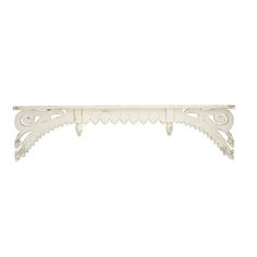 a white shelf with ornate designs on it