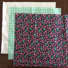 two pieces of fabric sitting next to each other on top of a wooden table with green and white checkered cloth