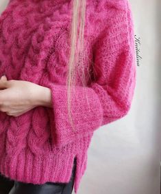 a woman with long blonde hair wearing a pink sweater