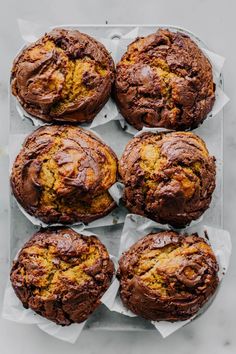 six chocolate muffins sitting on top of each other