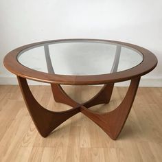 a wooden table with glass top sitting on a hard wood floor