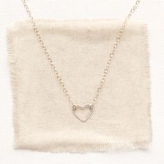 A simple, yet unique necklace to show your love. A simple forged silver heart hangs on silver chain. The heart is attached at two points, so it can change orientation from the side to right side up. Necklace measures 17" - 18 1/2" with lobster clasp and adjustable length chain closure. Small pearls frame the clasp and dangle down the back. Sterling silver. Your jewelry will arrive beautifully gift wrapped in a small box. Multiple items will be combined, unless separate boxes are requested. You will be able to complete this request during check out. If this is a gift being shipped directly to the recipient, you can use the gift box option during check out to include the gift message. If you do not use the gift option, there is no way for me to know these are gifts and your pieces will be wr Minimalist Nickel-free Heart Pendant Necklace, Minimalist Nickel-free Necklace For Valentine's Day, Minimalist Adjustable Heart Necklace, Minimalist Adjustable Heart Pendant Necklace, Minimalist Adjustable Heart Charm Necklaces, Simple Silver Heart Necklace For Valentine's Day, Adjustable Sterling Silver Heart Necklace For Everyday, Minimalist Charm Necklace With Heart Pendant, Minimalist Necklace With Lobster Clasp For Valentine's Day