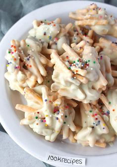 a white plate topped with cookies covered in frosting and sprinkles on top of a table