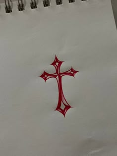 a cross drawn on top of a piece of paper