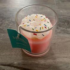 a doughnut with sprinkles is in a glass on the table next to a tag