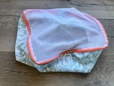 a blue and pink purse sitting on top of a wooden floor