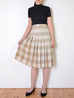 Cool vintage skirt made of gently textured, matte fabric - woven with plaid pattern in tones of beige and white. Flared, a line midi fit. Button and zip closure on the back. Unlined. The item has been pinned on the model Era: 70's Fabric: not given, feels like cotton to touch Condition: very good Estimated size: L / XL (please, check the measurements) Measurements (measured flat, need to be doubled to get the circumference): Waist: 45 cm / 17,7 inches Length: 72 cm / 28,3 inches Beige A-line Pleated Skirt For Fall, Fitted Beige Bottoms With Accordion Pleats, Fitted Beige Pleated Skirt For Fall, Fitted Box Pleat Pleated Skirt For Summer, Fitted Midi Pleated Skirt With Box Pleat, Fitted Accordion Pleats Skirt For Fall, Fall Knee-length Skirt With Accordion Pleats, Fitted Box Pleat Midi Pleated Skirt, Chic Plaid Pleated Skirt