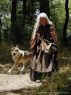 an old woman walking with a wolf in the woods