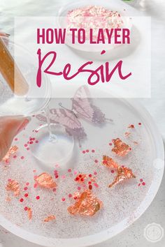 a white plate topped with butterflies next to a glass filled with liquid and pink sprinkles