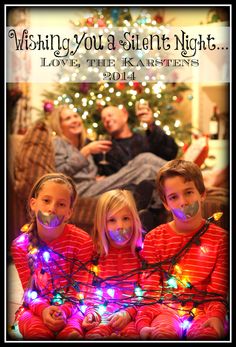 three children with their faces covered in christmas lights