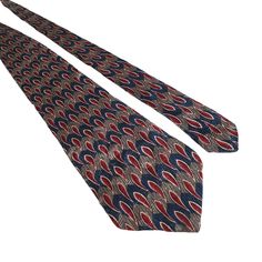 Elegant vintage tie featuring a sophisticated abstract pattern in red, blue, and brown. Crafted from luxurious silk, ideal for formal settings. * 100% Silk * Abstract Pattern * Vibrant Red Blue & Brown Colors * Width: 3.5 inches * Slight fraying at the tip of the tie. * Width: 3.5 inches  * Length: 57 inches Features: * All Seasons * Geometric Size: Regular Condition: Pre-Owned Good This tie is in great vintage condition. This item has been cleaned and kept in a home that is free of smoke/pets. Luxury Silk Suit And Tie Accessories For Formal Occasion, Blue Office, Silk Ties, Tie Accessories, Vibrant Red, Suit And Tie, Brown Color, Abstract Pattern, Neck Tie