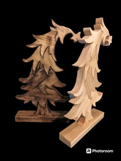 two wooden sculptures made to look like pine trees, one with an eagle on it