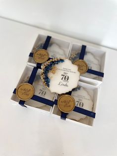 an open gift box with some blue and white items in it on a table top