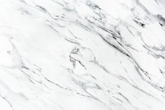 a white marble textured surface with black and grey veining on it's edges