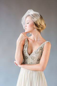 a woman in a wedding dress with a veil on her head looking off to the side