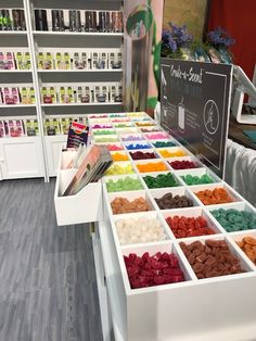 there are many different colored candies on the counter in this store that is selling them